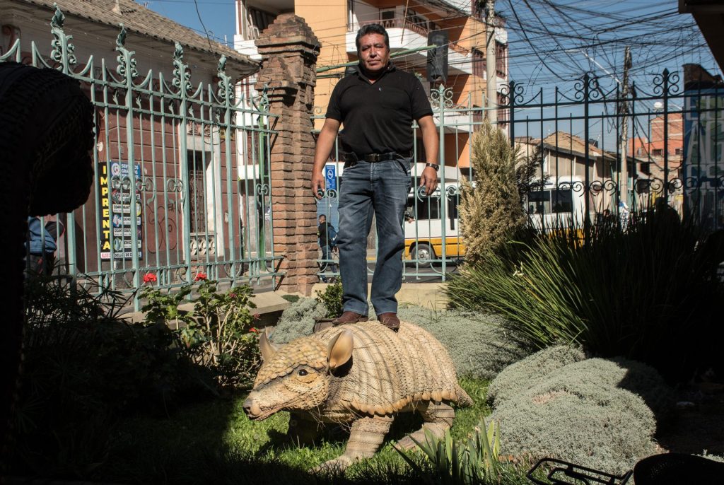 El artista plástico Sandro Arellano (c) posa, el pasado 1 de junio, junto a una de sus esculturas hecha de neumáticos descartados, en Cochabamba (Bolivia), con lo que busca crear conciencia ambiental. EFE/Jorge Ábrego