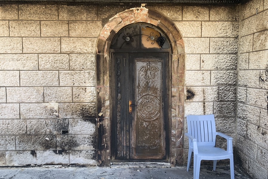 Puerta de una vivienda palestina en Turmusayya, quemada y dañada tras un reciente ataque por parte de colonos israelíes