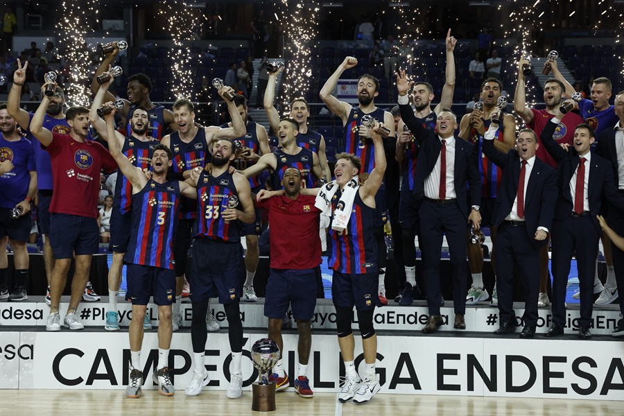 Los jugadores y técnicos del Barça celebran con el trofeo el título de Liga tras el tercer partido de la final de la Liga Endesa de baloncesto que Real Madrid y Barça disputaron este martes en el WiZink Center