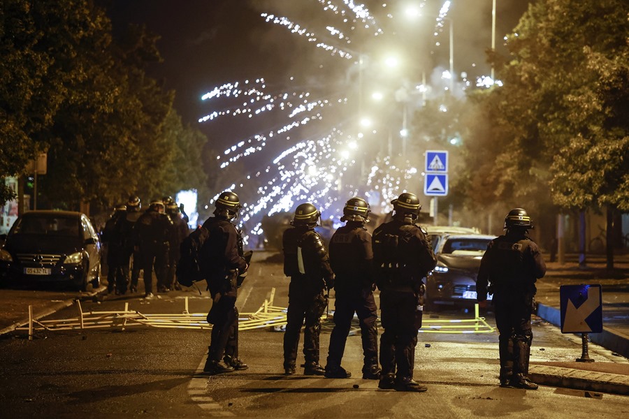 Manifestantes lanzan fuegos artificiales a la policía antidisturbios francesa durante los disturbios en Nanterre, cerca de París, Francia