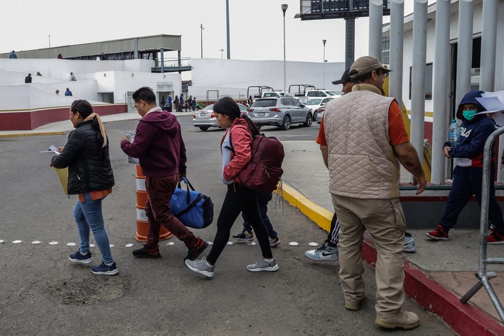 Migrantes esperan afuera de la garita internacional del Chaparral, el 10 de junio de 2023, en la ciudad de Tijuana (México), en la frontera con EE.UU.. EFE/Joebeth Terríquez