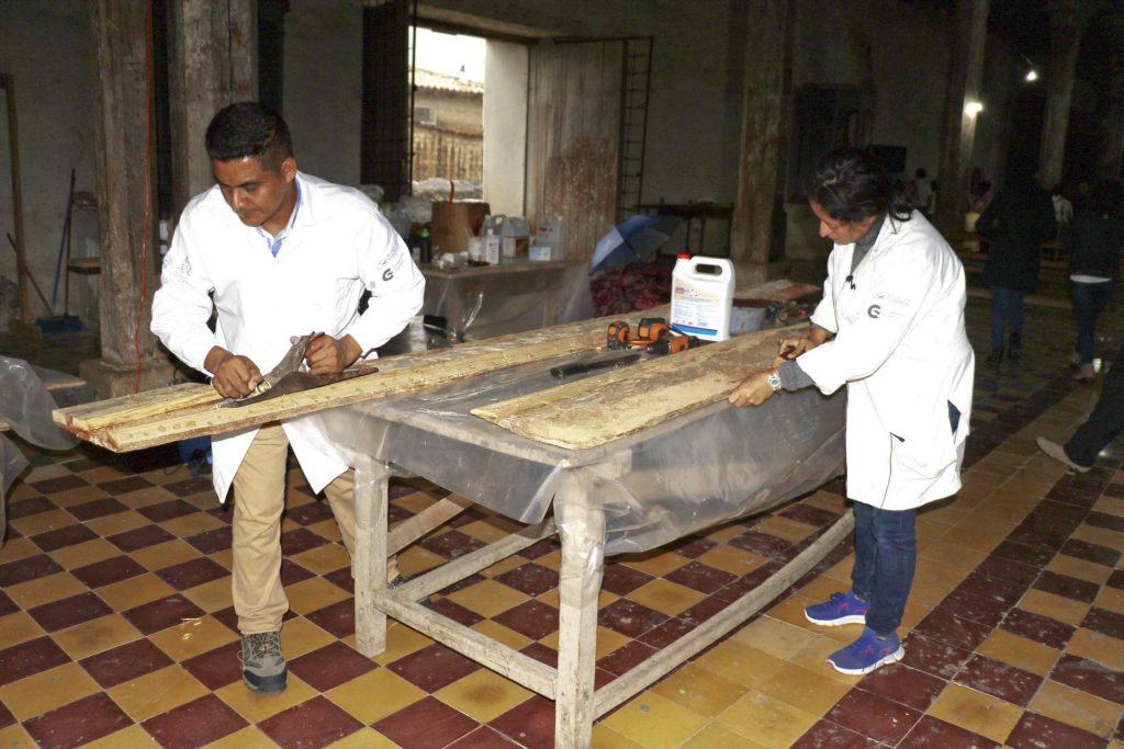 Los restauradores Leonel Santos (i) y Lilian Janeth Mazariegos (d) trabajan en la restauración de iglesia de San Manuel de Colohete, el 7 de junio de 2023, en el departamento de Lempira (Honduras). EFE/Germán Reyes