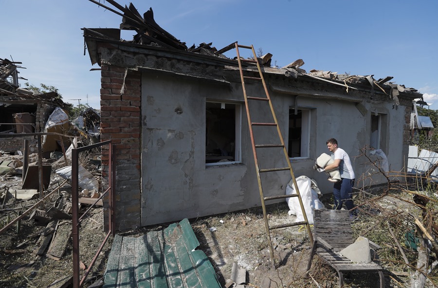 Varias personas rescatan sus pertenencias de una vivienda dañanada por la caida de un cohete, en la aldea de Stari Petrivtsi cerca de Kiev, el viernes 16 de junio