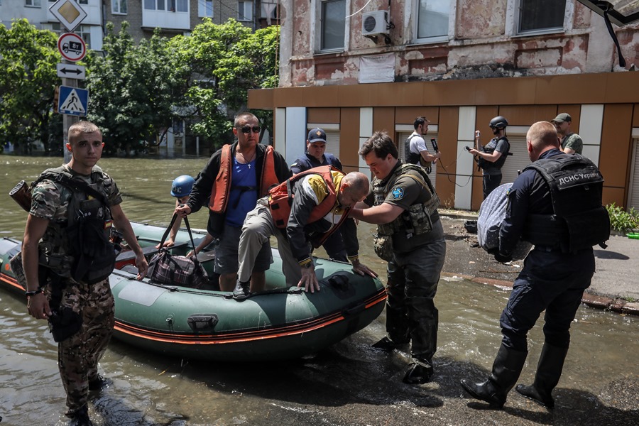 Efectivos de los servicios de emergencia evacúan a vecinos de un área inundada de Jersón, en el sur de Ucrania