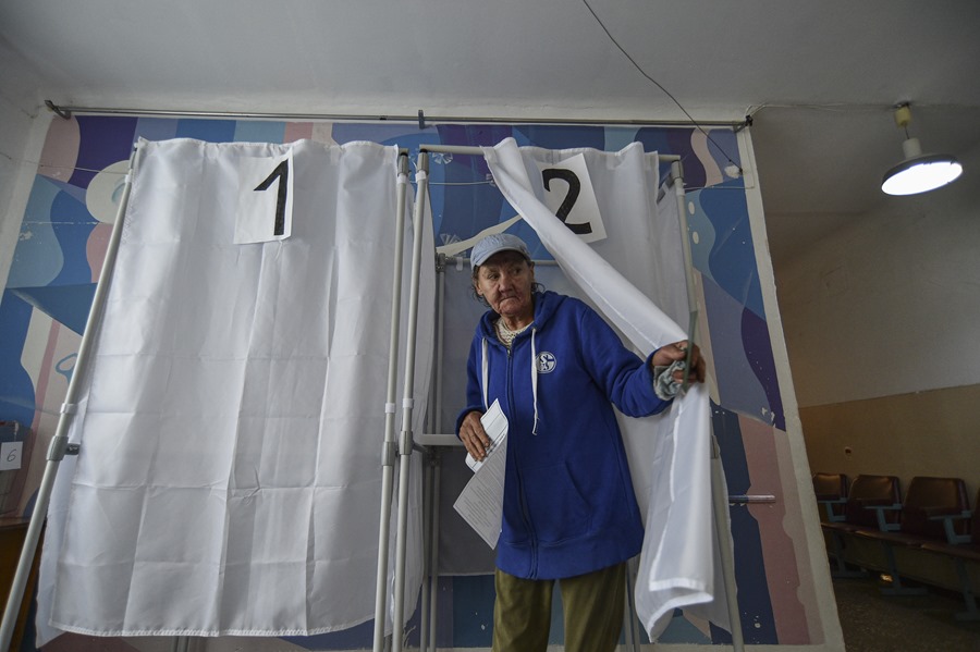 Una mujer se dispone a votar en un colegio de Melitopol, en la región de Zaporiyia, en el referéndum convocado en septiembre de 2022 en las regiones de Ucrania anexionada por Rusia.