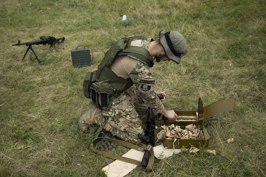 Un combatiente del Ejército Azov carga sus armas durante un entrenamiento, en las afueras de Járkov (Ucrania).