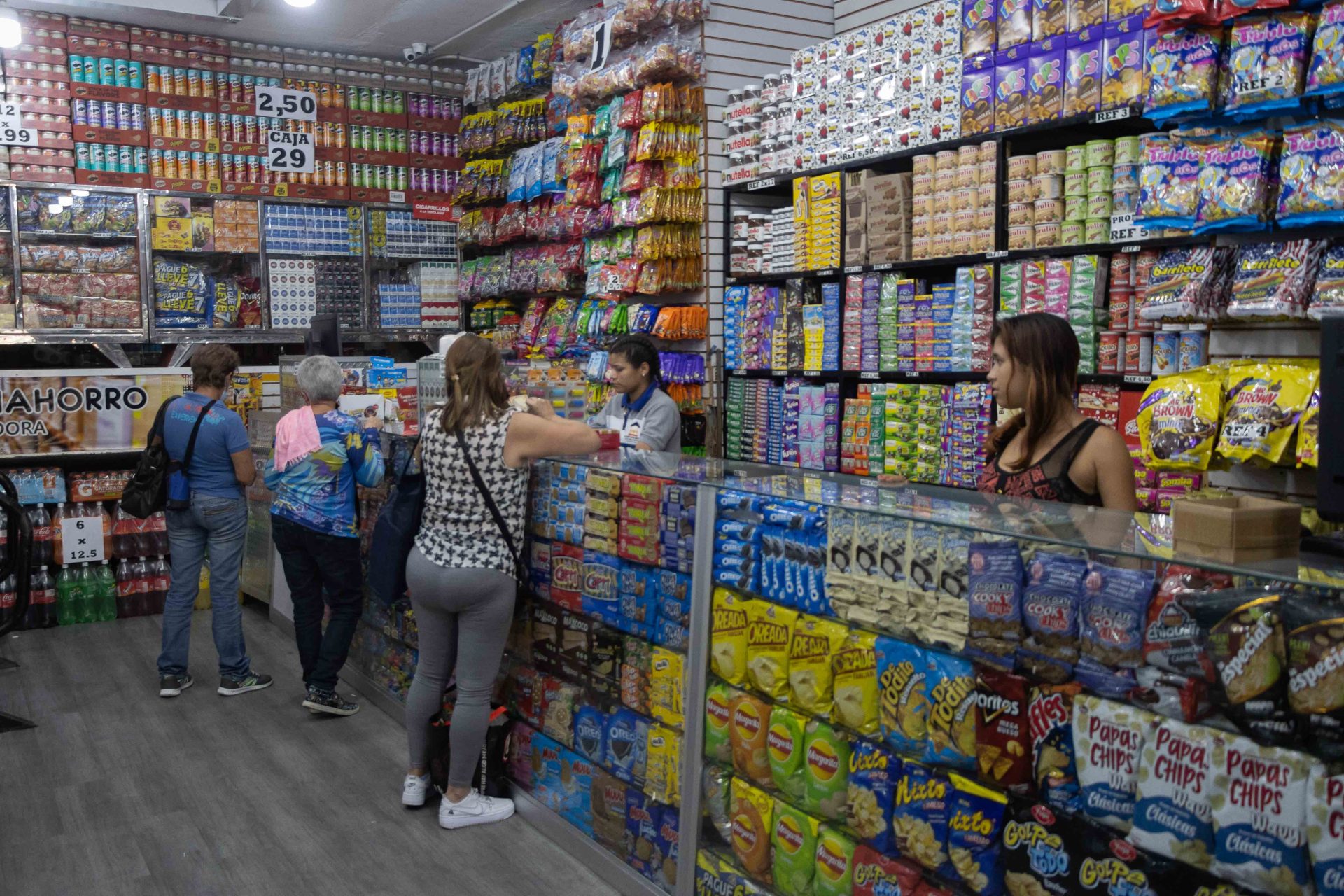 Fotografía de archivo que muestra a varias personas que compran en una tienda de Caracas (Venezuela), donde los clientes tratan de hacer que sus salarios rindan. EFE/Ronald Peña