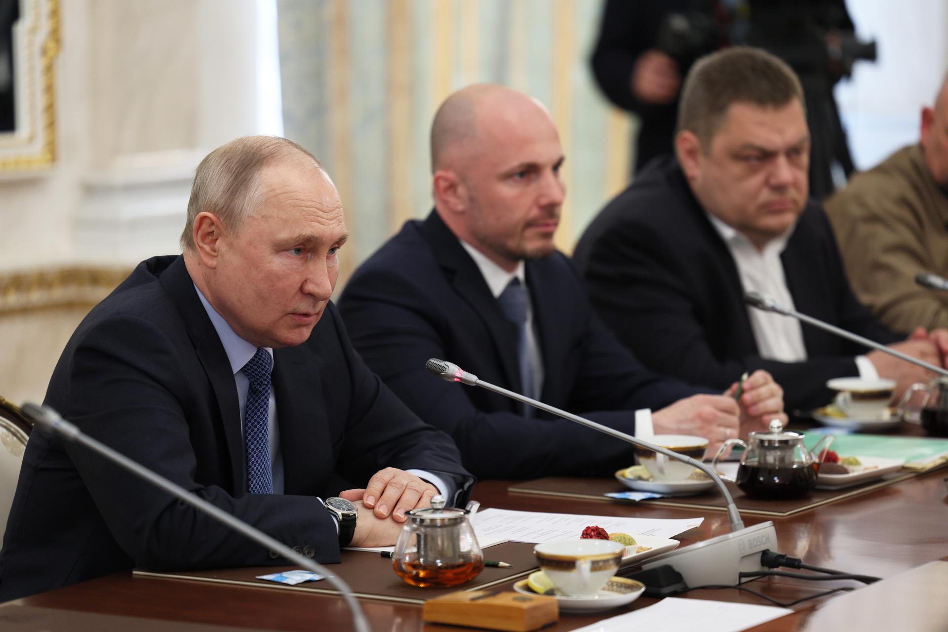 El presidente ruso, Vladimir Putin (L), preside una reunión con periodistas de guerra rusos en Moscú.