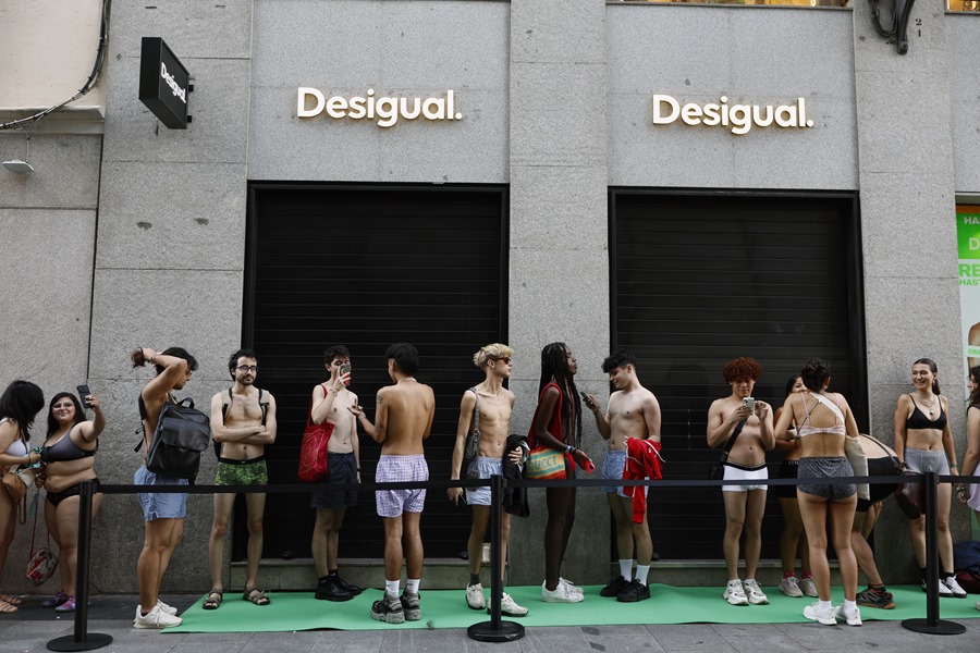 Varias personas en ropa interior esperan la apertura de una tienda de Desigual en Madrid. 