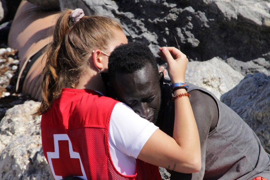 Una voluntaria de Cruz Roja abraza a un inmigrante en Ceuta
