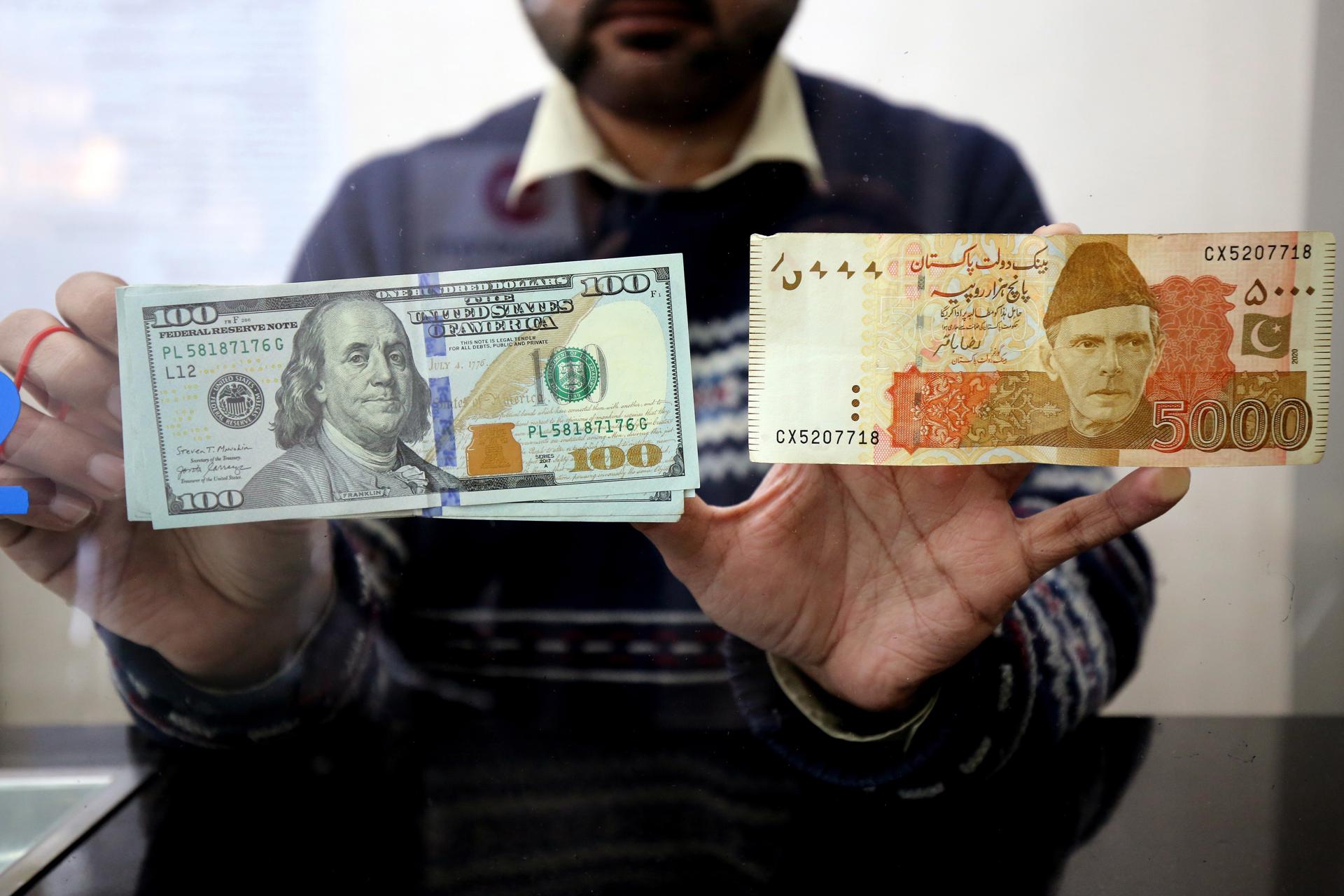 A currency exchange dealer sorts US dollars and Pakistani rupees at a money exchange company in Peshawar, Pakistan, 27 January 2023. EFE-EPA FILE/BILAWAL ARBAB
