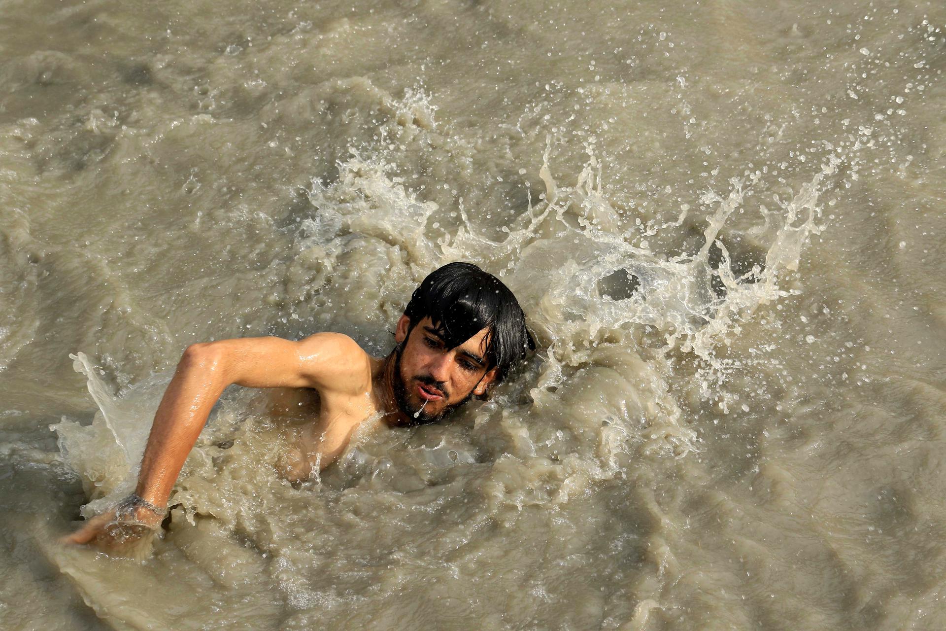 A Pakistani man swims to cool off at a canal in Peshawar, Pakistan, 16 June 2023. EFE-EPA/ARSHAD ARBAB
