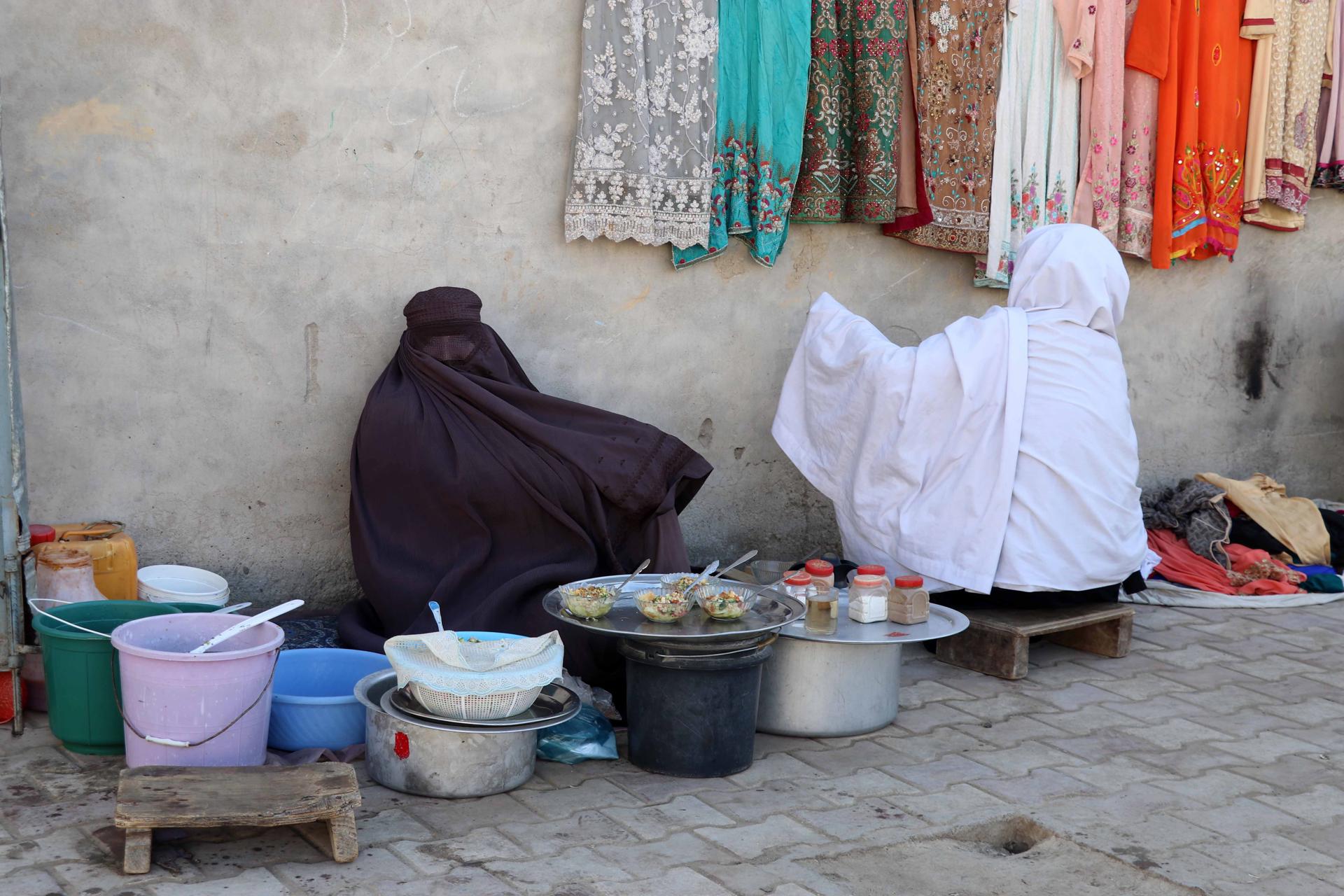 Afghan women sell used clothes and fruit products on a road side, in Kandahar, Afghanistan, 07 March 2023. EFE/EPA/FILE/STRINGER