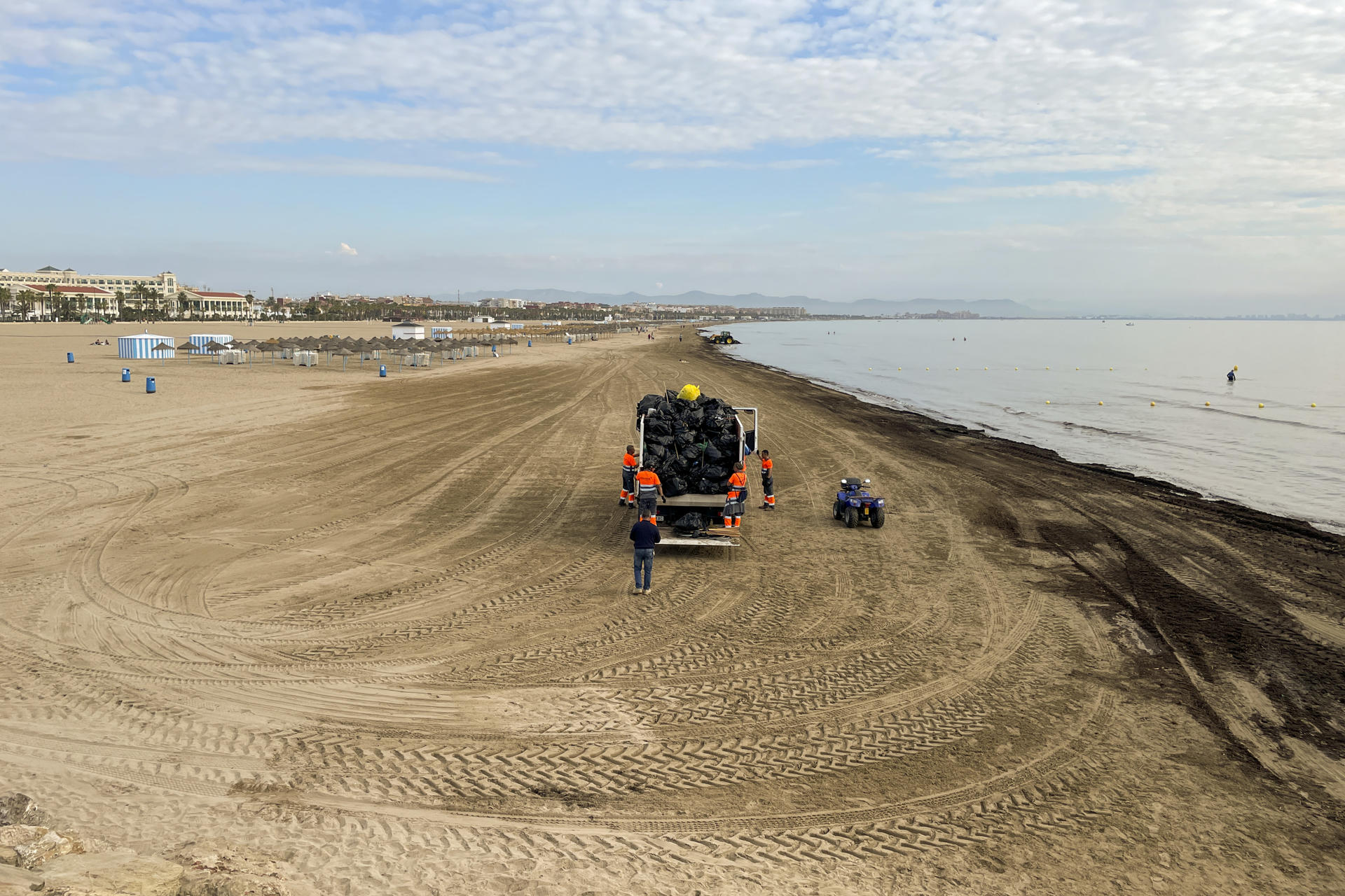 En la imagen, operarios del ayuntamiento limpian la playa de la Malvarrosa de valencai a primeras horas del hoy, domingo 4 de Junio.EFE/ Juan Carlos Cárdenas