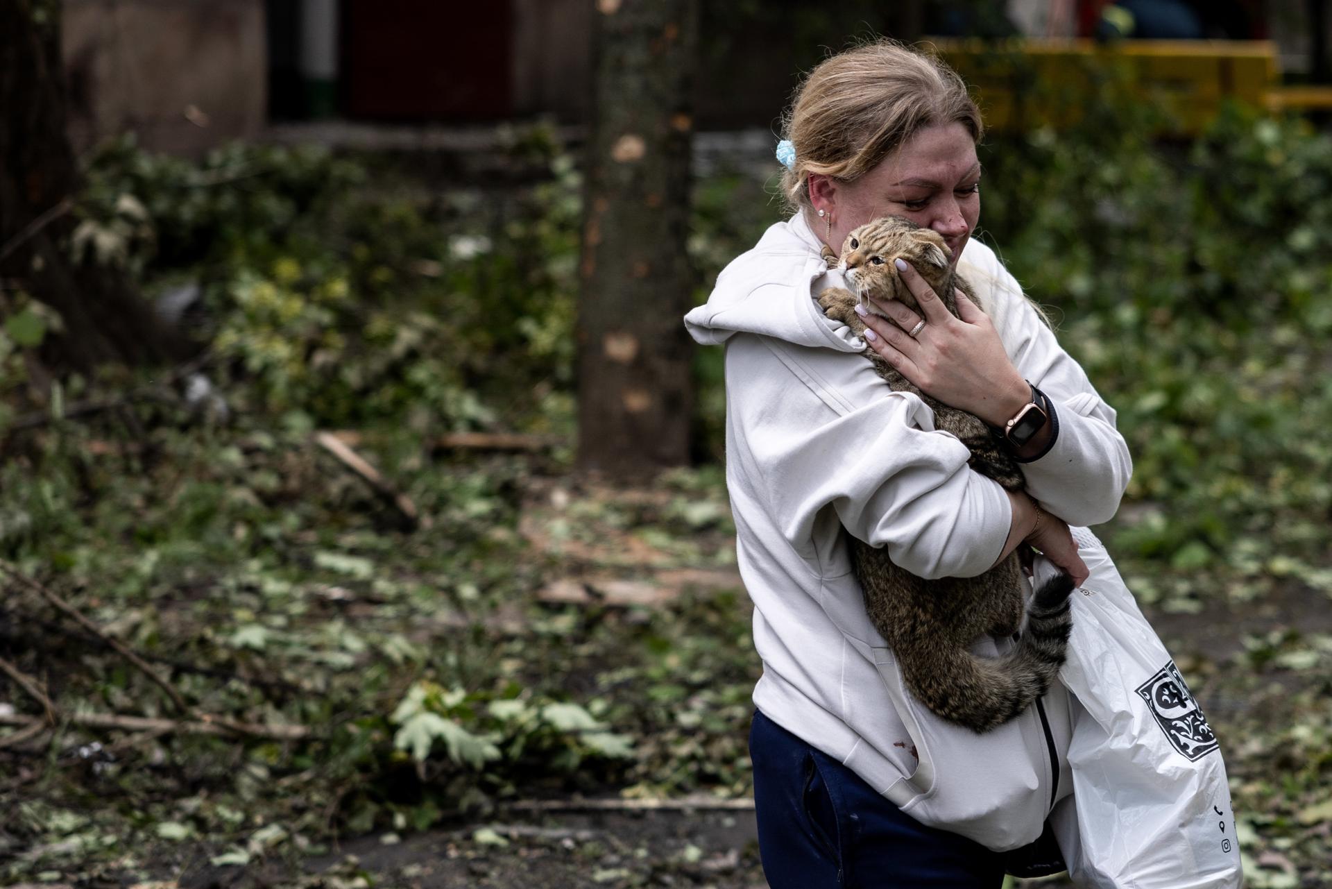 A woman holds her cat at the scene of an apartment block, hit by a Russian missile, in Kryvy Rih, Dnipropetrovsk region, Ukraine, 13 June 2023. EFE/EPA/STAS KOZLIUK