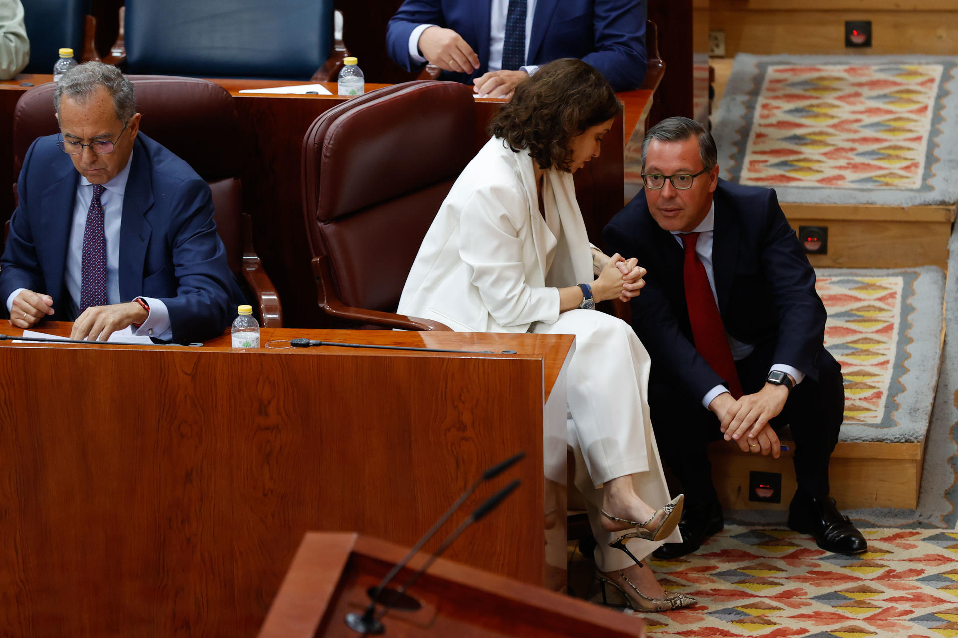 La presidenta en funciones de la Comunidad de Madrid, Isabel Díaz Ayuso (c) conversa con el diputado Alfonso Serrano (d) durante la constitución de la Asamblea de Madrid este martes. EFE/ Juan Carlos Hidalgo