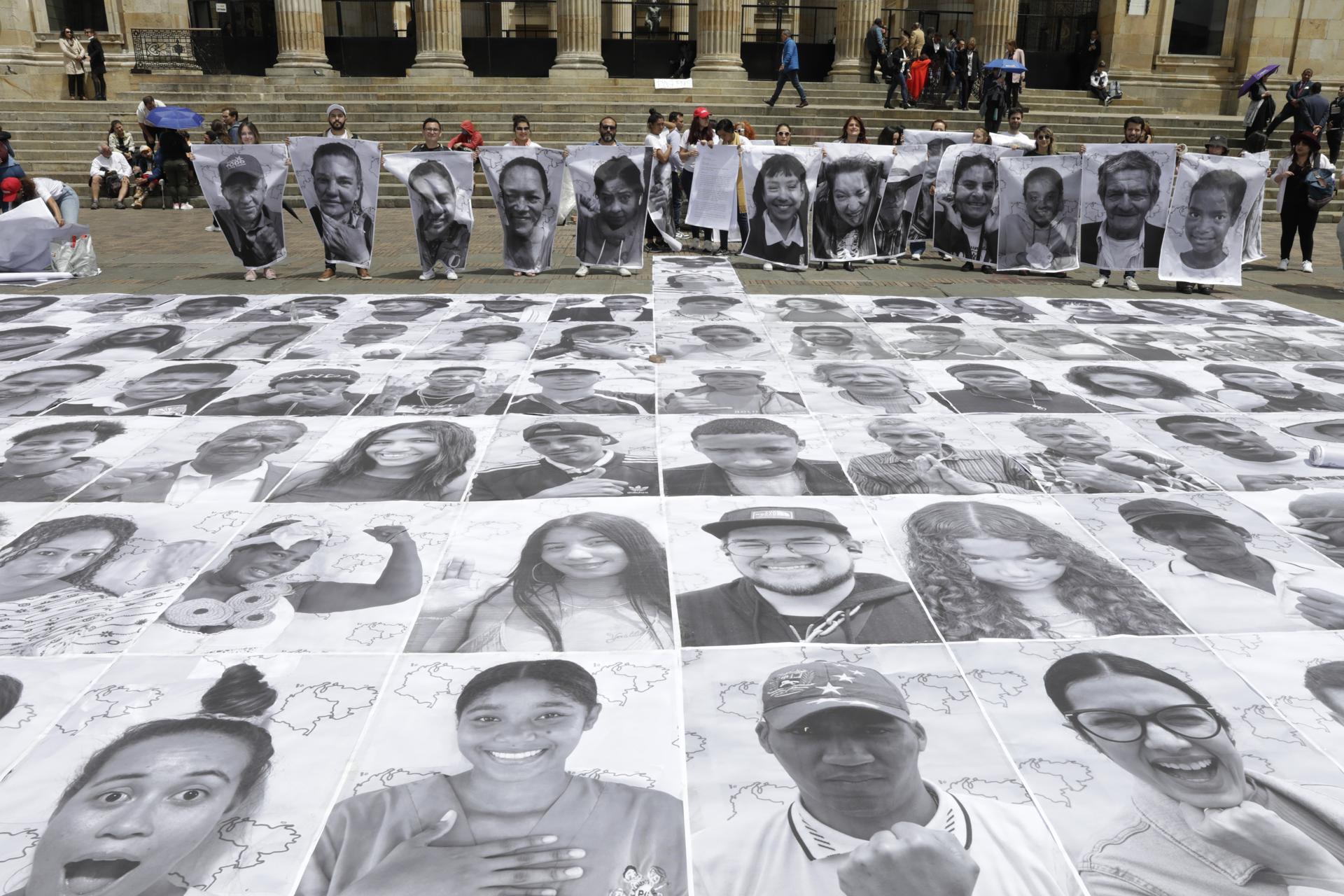 Ciudadanos y activistas participan hoy de una intervención que muestra 400 rostros de comunidad migrante, refugiada, retornada y receptora, con motivo del Día Mundial del Refugiado, en la Plaza de Bolívar, en Bogotá (Colombia). EFE/Carlos Ortega