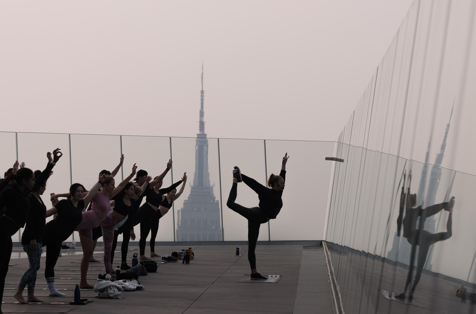 People attend a morning yoga class on The Edge observation deck as a haze caused by smoke from wildfires burning in Canada hangs over Manhattan in New York, USA, 07 June 2023. EFE/EPA/JUSTIN LANE
