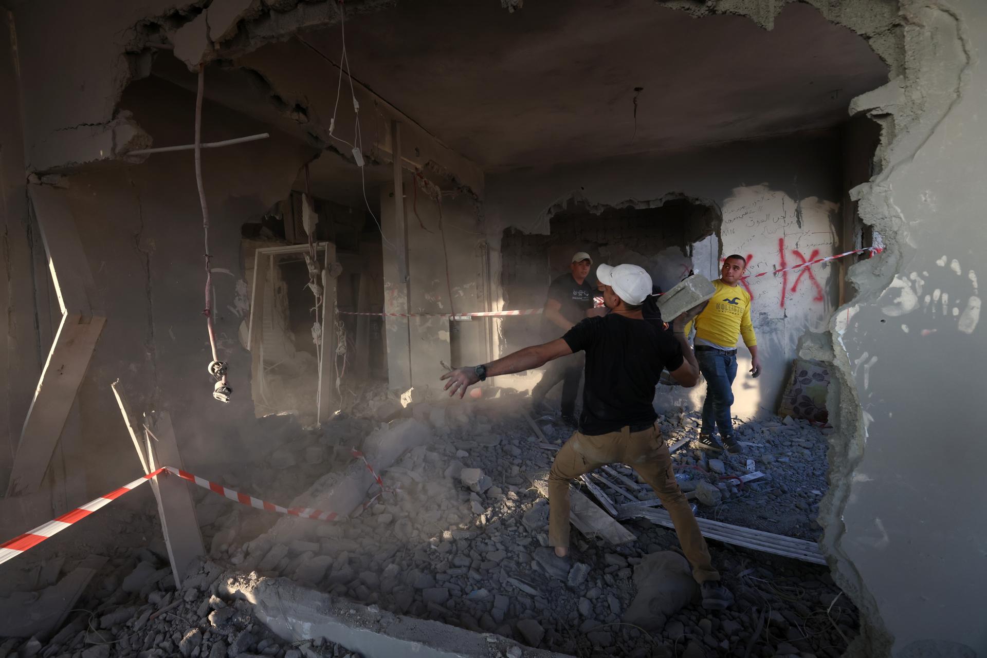 People clear debris from the house of Palestinian prisoner Kamal Jouri after it was destroyed during an overnight raid by Israeli forces in the West Bank city of Nablus, 22 June 2023.EFE/EPA/ALAA BADARNEH
