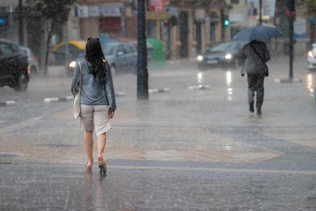 Dos personas caminan bajo la lluvia, en un día de este mes de mayo. EFE/Manuel Bruque
