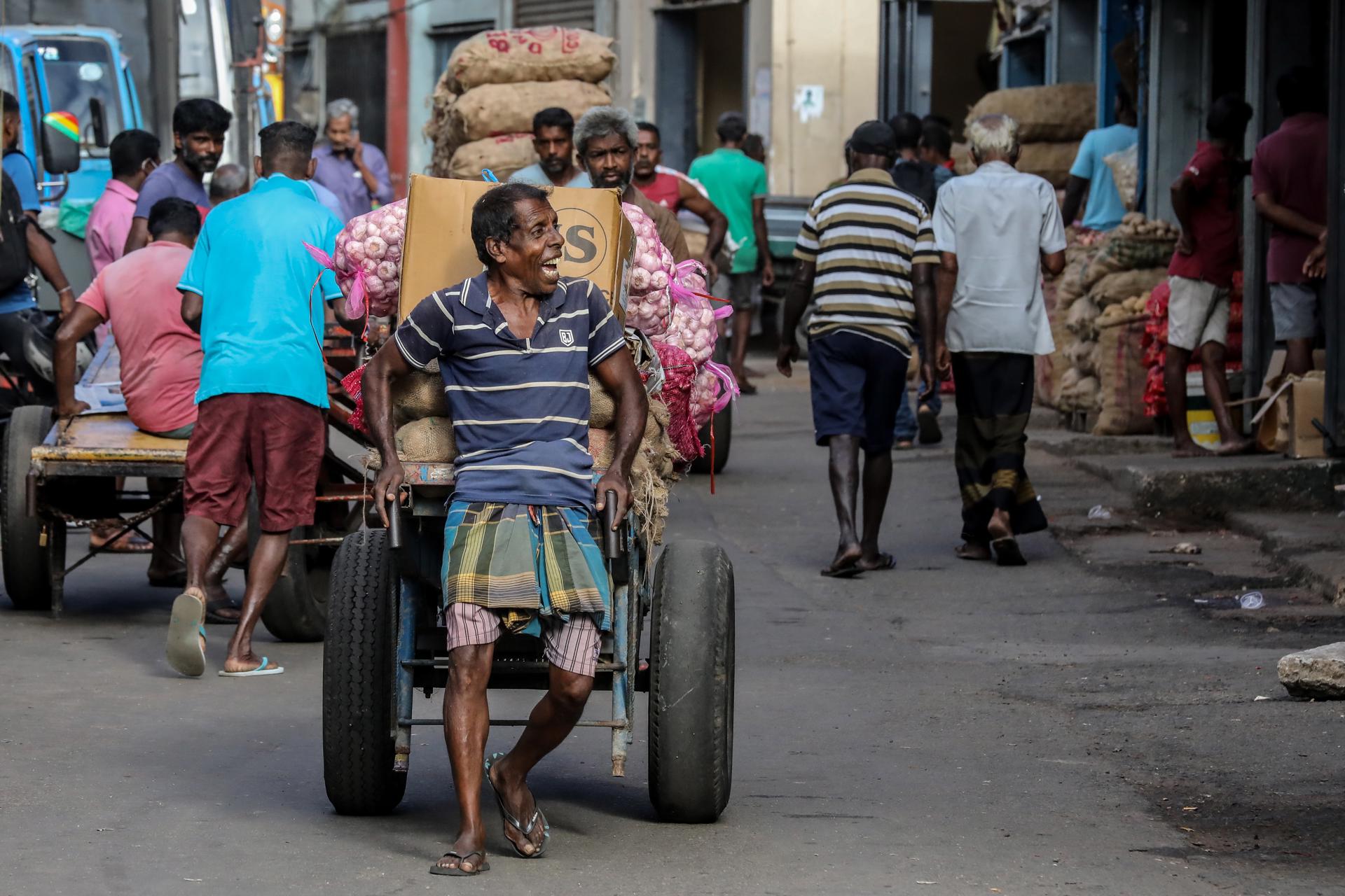 A hand-cart puller carries sacks of onion at a local market in Colombo, Sri Lanka, 25 August 2022. EFE/EPA/CHAMILA KARUNARATHNE

