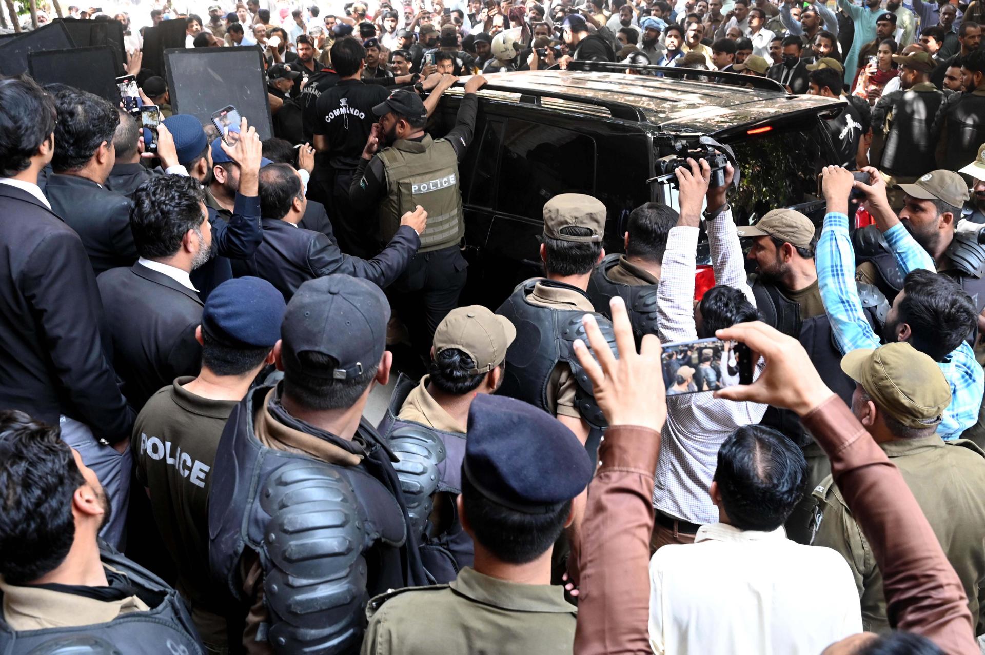Police and private security personnel with bulletproof shields escort a vehicle carrying Pakistan's former Prime Minister Imran Khan (not pictured) as he arrives at the Lahore High Court for a pre-arrest bail in a murder case related to one of his party's workers, in Lahore, Pakistan, 06 June 2023. EFE-EPA/RAHAT DAR