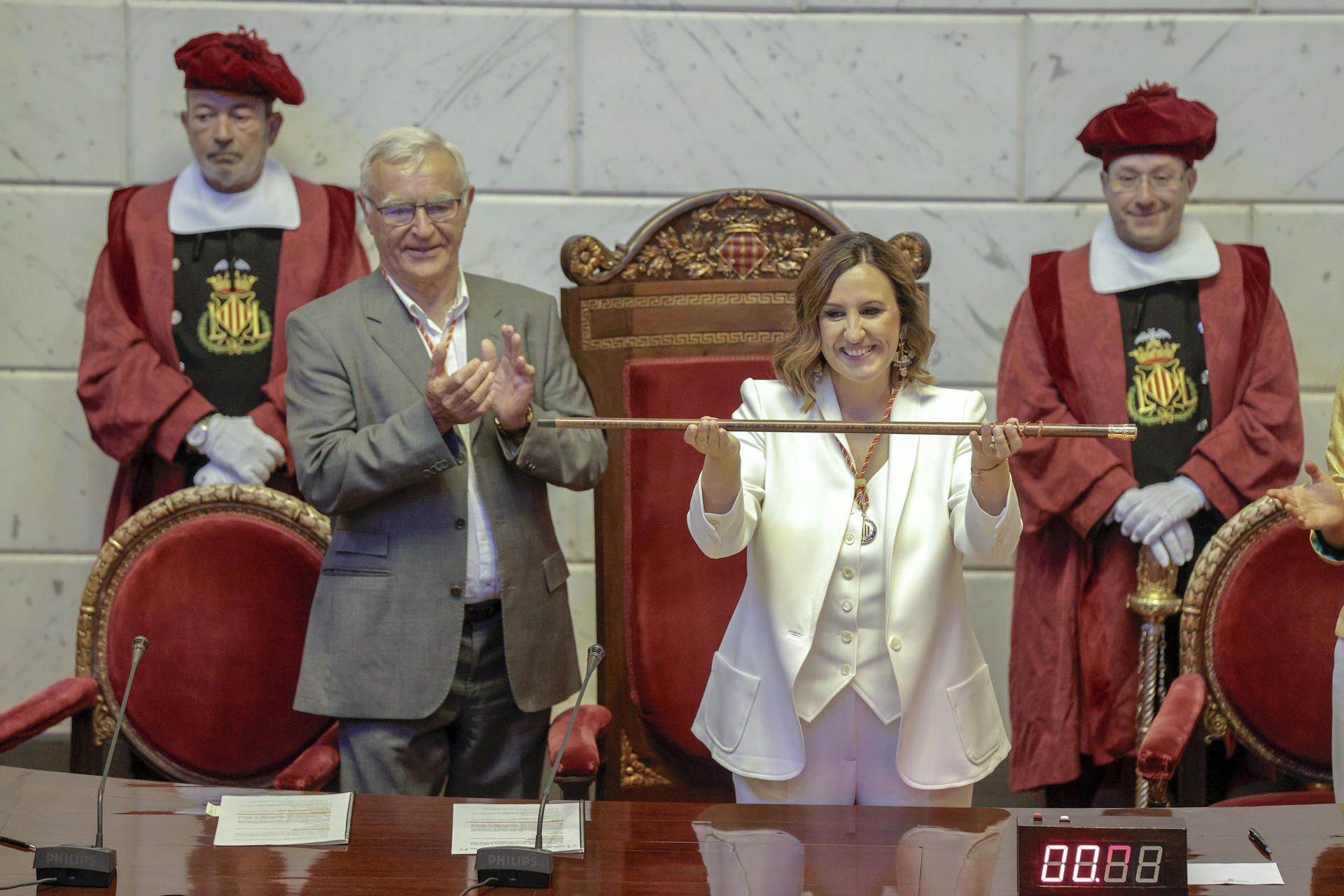La nueva alcaldesa de Valencia, Maria José Catalá, conl a vara de mando tras recibierla de manos del exalcalde, Joan Ribó (i) . EFE/ Manuel Bruque