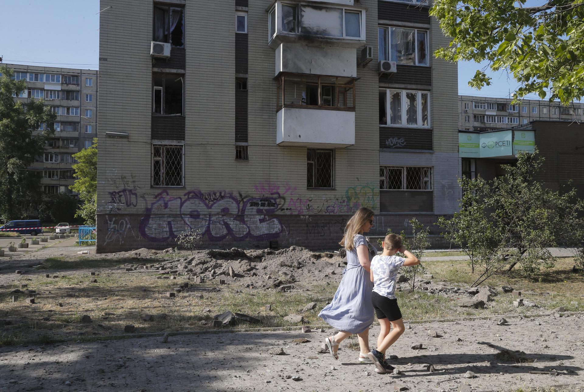 A woman and a child walk near a damaged residential building after a missile strike in Kyiv (Kiev), Ukraine, 01 June 2023, amid the Russian invasion. EFE-EPA/SERGEY DOLZHENKO
