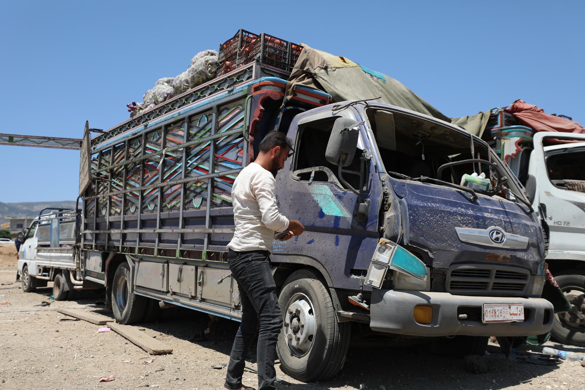 A man stands next to a damaged truck at a vegetable market following a reported airstrike in Idlib, Syria, 25 June 2023. EFE-EPA/YAHYA NEMAH