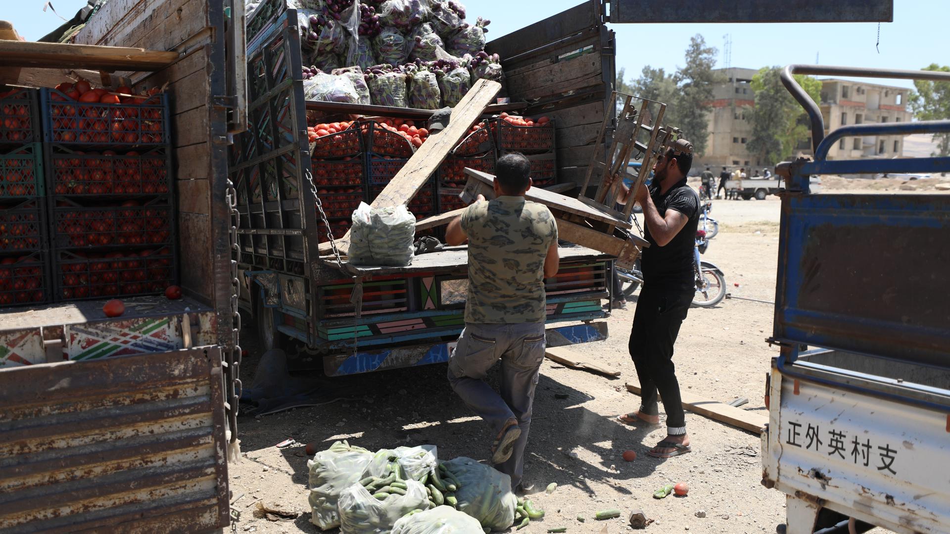 People inspect a damaged truck at a vegetable market following a reported airstrike in Idlib, Syria, 25 June 2023. EFE-EPA/YAHYA NEMAH
