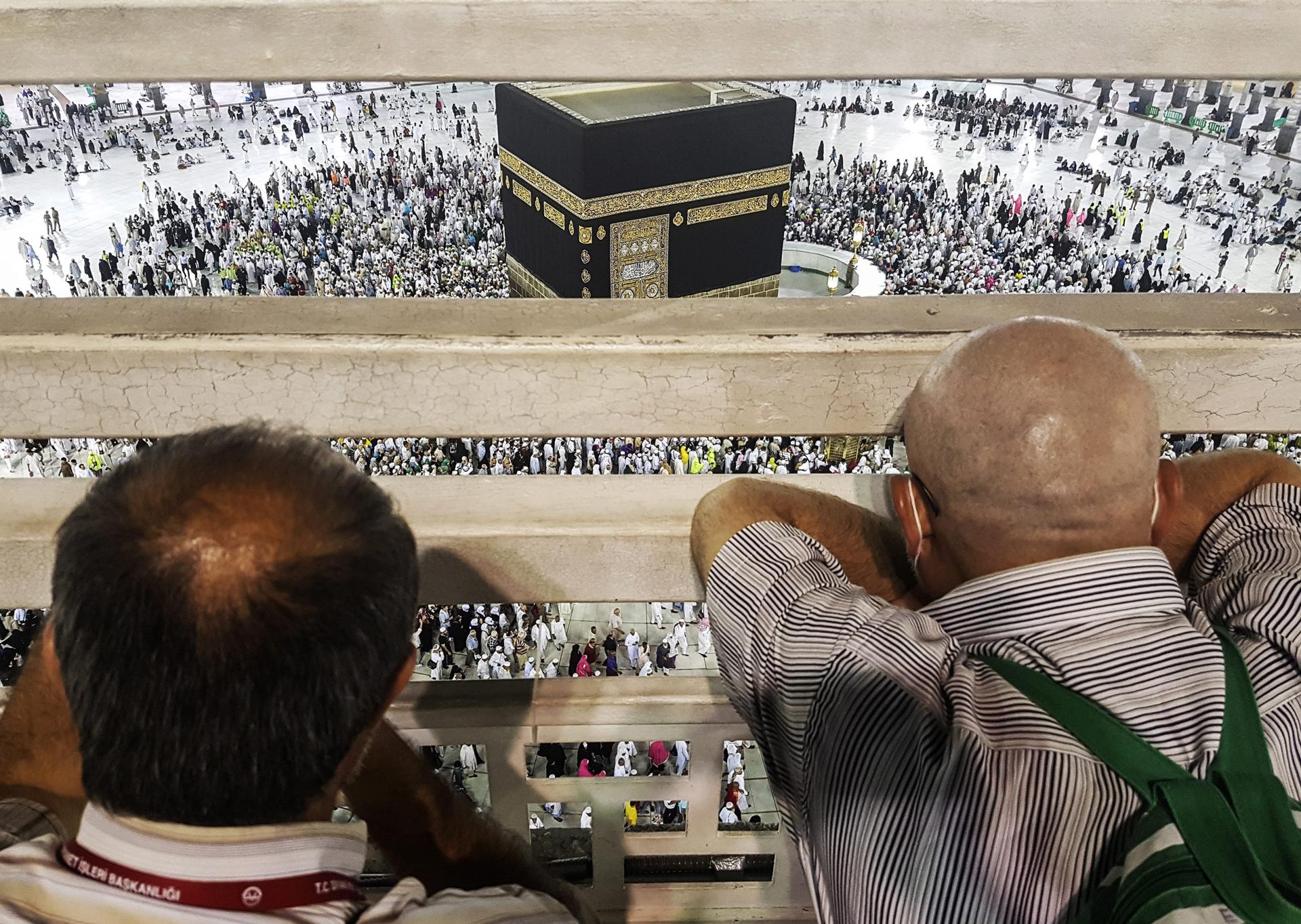 Two men look at the Kaaba as pilgrims circumvent it as they perform last 'tawaf' (circumambulate the Kaaba seven times in a counterclockwise direction) and important ritual to finish the hajj pilgrimage at the Masjid al-Haram (Grand Mosque), during Hajj at the Holy City of Mecca, Saudi Arabia, 14 September 2016. EPA/FAZRY ISMAIL
