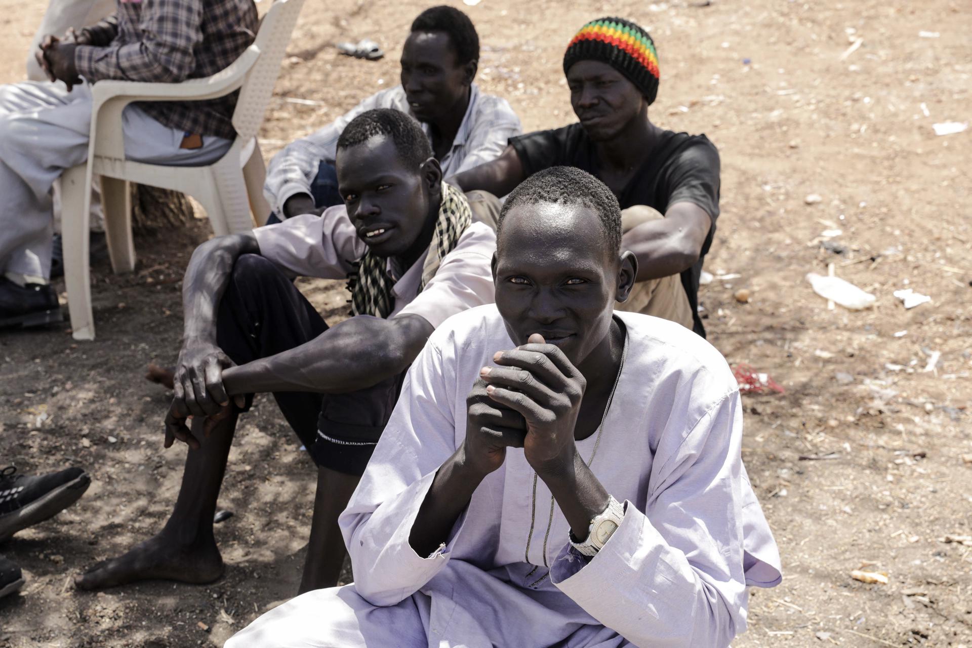 Men who fled Khartoum look on as they wait for transport to move toward the town of Renk, at Wunthaou near the border with Sudan, South Sudan, 12 May 2023. EFE-EPA/FILE/AMEL PAIN