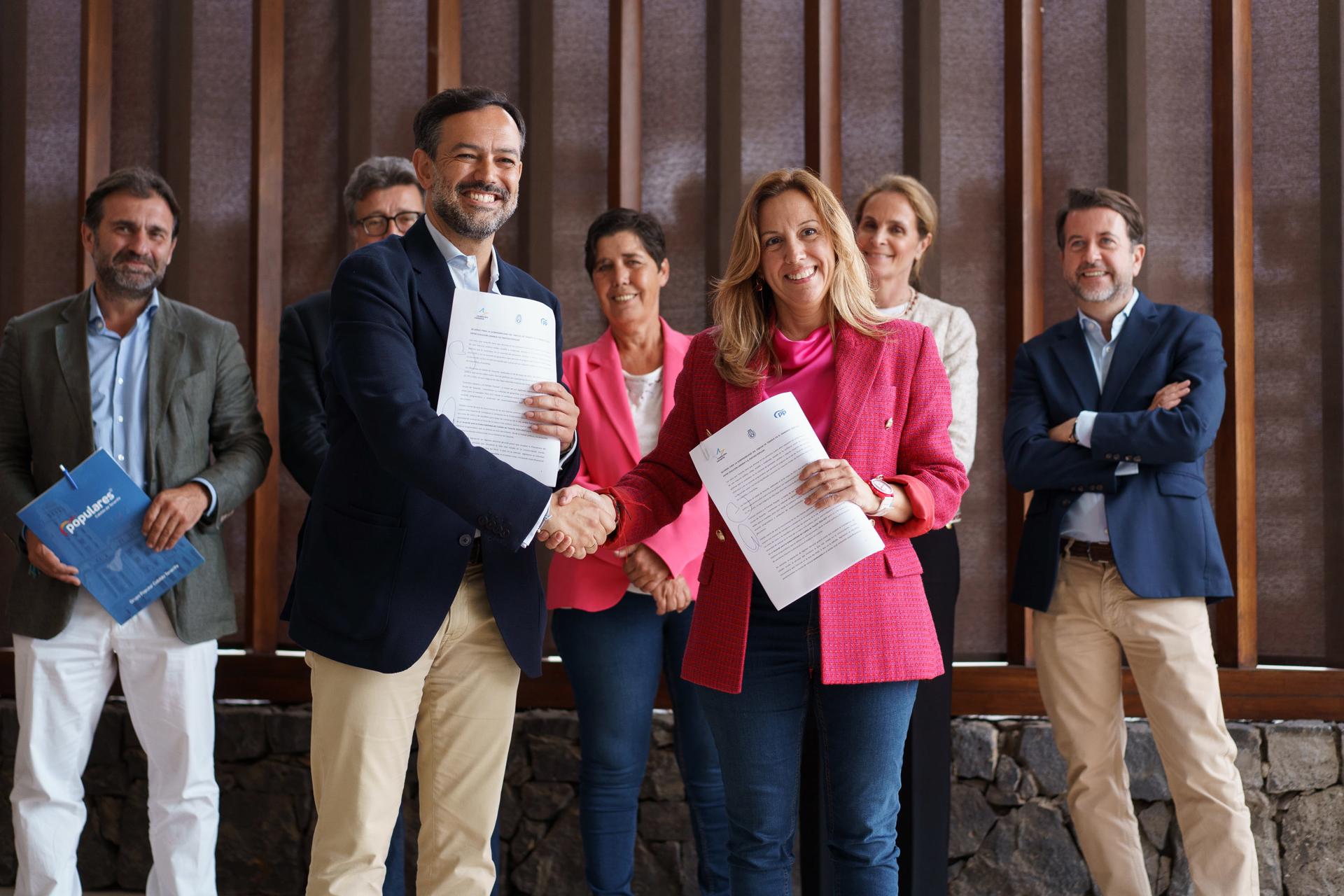 Los candidatos de Coalición Canaria y Partido Popular a la presidencia del Cabildo de Tenerife, Rosa Dávila (d) y Lope Afonso (i), respectivamente, firman un acuerdo para gobernar de forma conjunta la institución insular. EFE/Ramón de la Rocha
