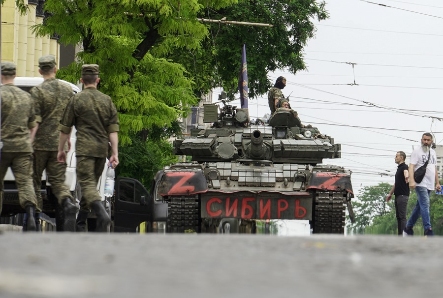 Soldados de la compañía militar privada (PMC) Wagner Group montan un tanque que dice 'Siberia' en una calle del centro de Rostov-on-Don