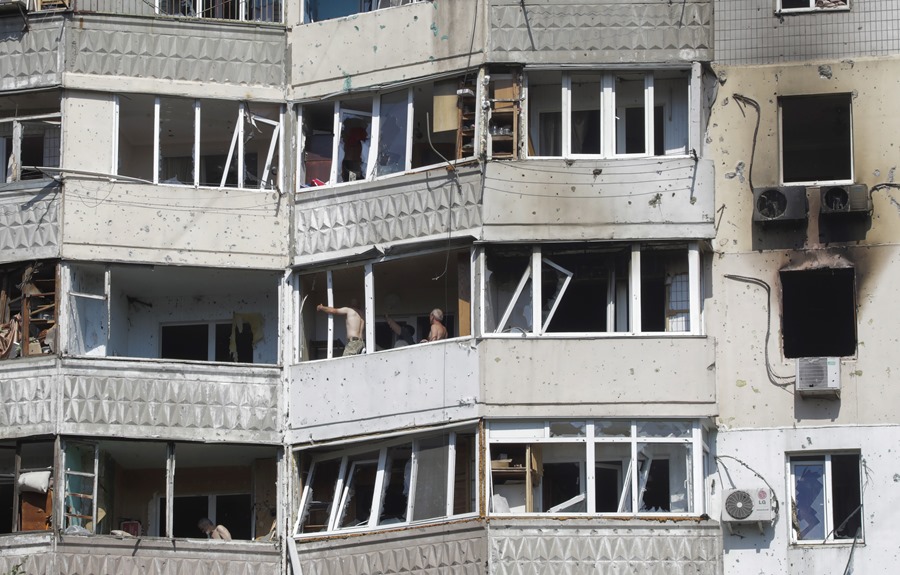 Un grupo de personas en edificios dañador por las bombas en Odesa. 