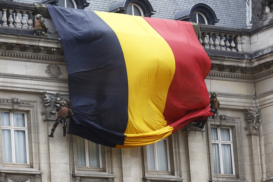 Soldados de las Fuerzas Armadas belgas desplegaban una bandera gigante de Bélgica durante el desfile del Día Nacional en Bruselas