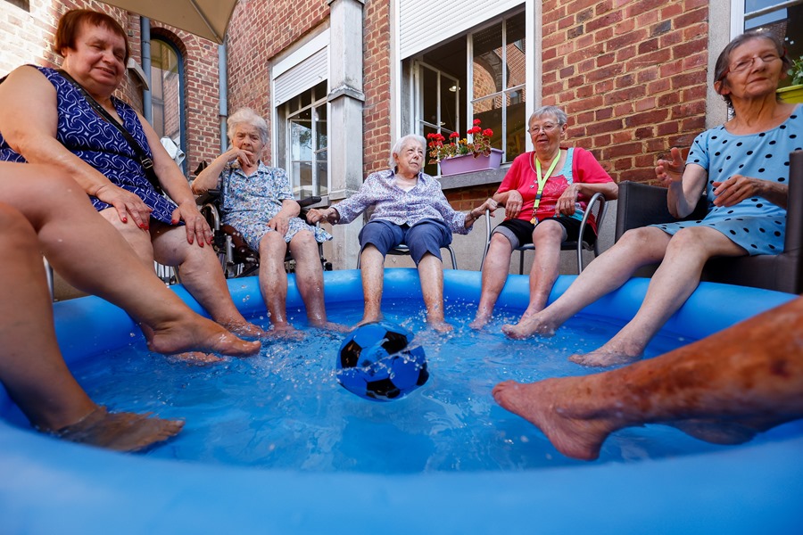 Un grupo de mujeres se refresca con los pies metidos en una piscina hinchable en una residencia de ancianos