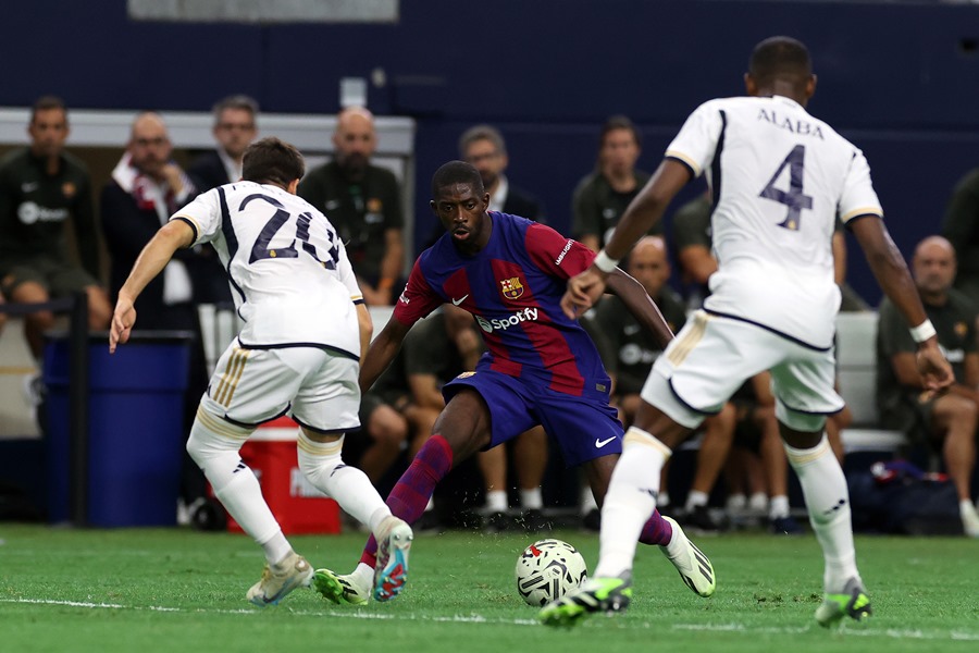 El delantero del FC Barcelona Ousmane Dembele (c) en una acción ante los defensas del Real Madrid Fran Garcia (i) y David Alaba (d) en el partido amistoso que ambos equipos han disputado este sábado en Dallas, EE. UU. 