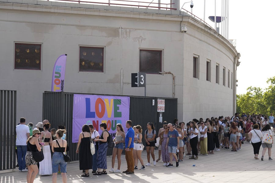 Centenares de personas hacen cola para comprar memorabilia en el Estadio Olímpico de Barcelona que dará mañana la bienvenida a España a Harry Styles