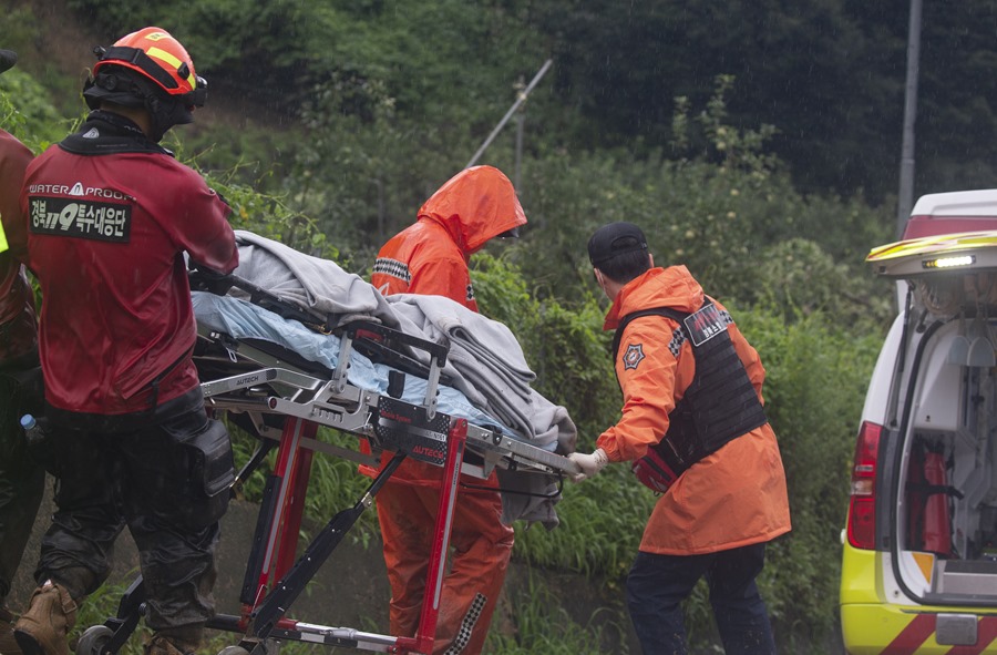 Trabajadores de emergencia trasladan el cuerpo de una persona fallecida tras un deslizamiento de tierra causado por las fuertes lluvias que azotan desde hace días Corea del Sur. 