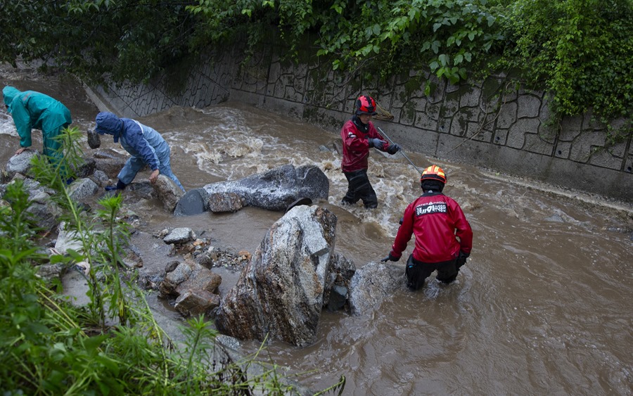 Operarios de los servicios de emergencia de Corea del Sur trabajan en las labores de búsqueda de posibles víctimas tras un deslizamiento de tierra causado por fuertes lluvias