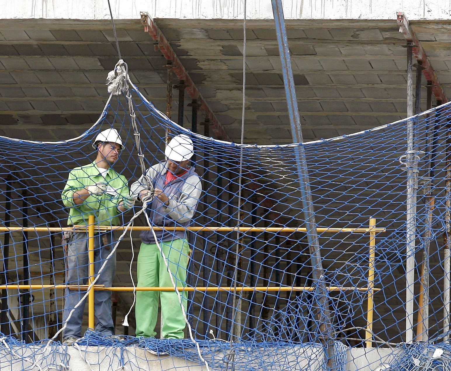 Dos operarios trabajan en la construcción de un edificio en Santander. EFE/Esteban Cobo.