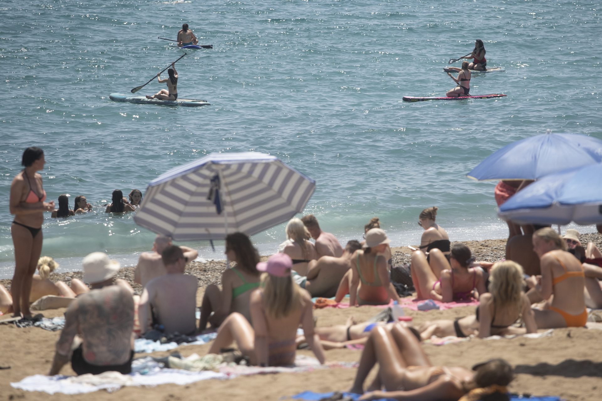 Cientos de personas abarrotan la playa de la Barceloneta en la ciudad condal, este domingo en plena ola de calor.