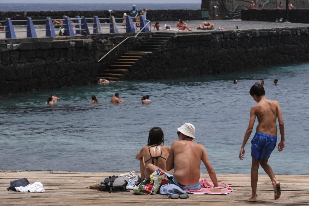 Un grupo de personas disfruta de un día de playa en el Puertito de Güimar en Tenerife, durante una jornada marcada por las altas temperaturas. EFE/Alberto Valdés
