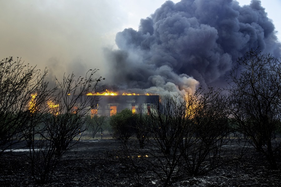 Una fábrica de plásticos arde, alcanzada por el incendio forestal declarado en la aldea de Sesklo, en Volos, Grecia central oriental. 