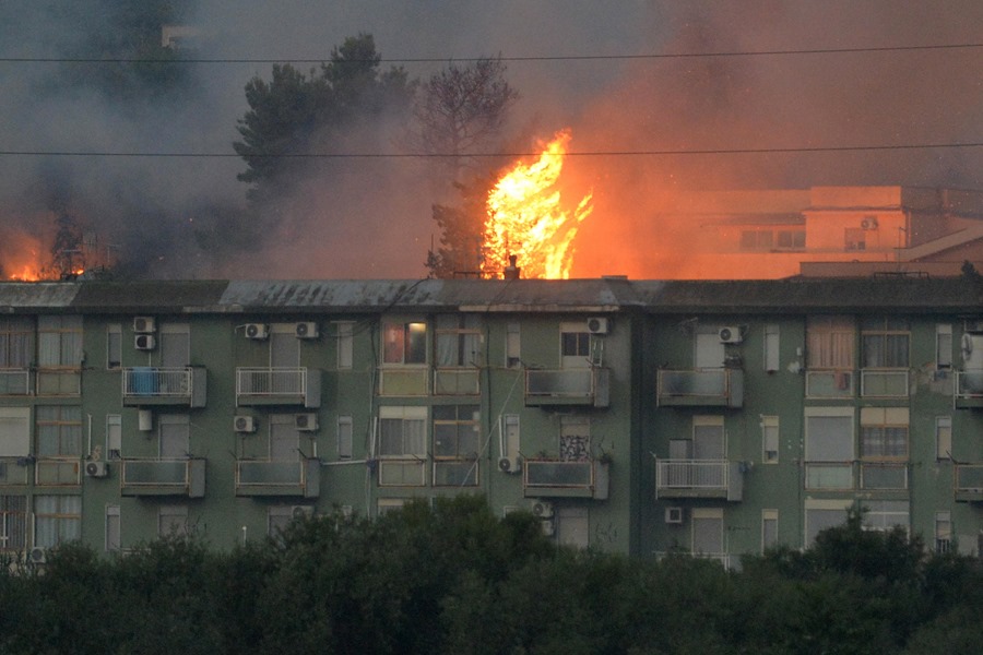 Una columna de fuego se eleva tras un bloque de viviendas en el área de Monte Grifone en la ciudad de Ciaculli, cerca de Palermo, 