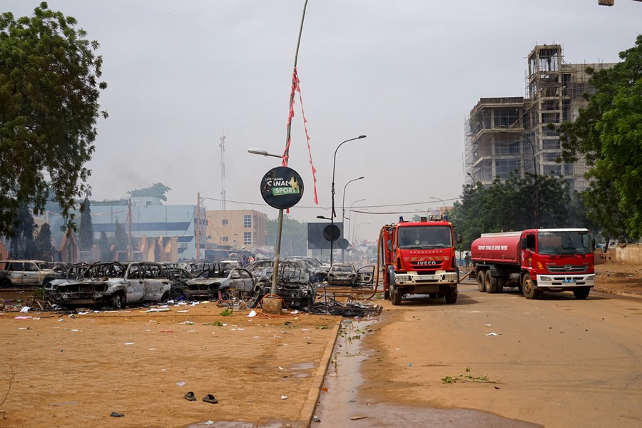 Camiones de bomberos junto a autos incendiados en un estacionamiento cerca de la sede del Partido para la Democracia y el Socialismo de Níger en Niamey, Níger, el 27 de julio de 2023