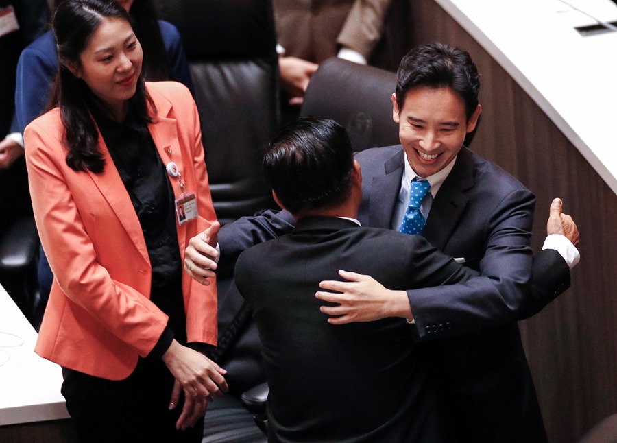 El líder del Partido Avanzar y candidato a primer ministro de Tailandia, Pita Limjaroenrat (R), recibe un abrazo de un miembro de su partido antes de abandonar el Parlamento