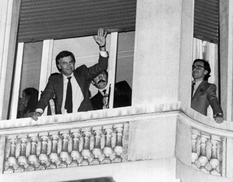 El secretario general  del PSOE,  Felipe González (C), y Alfonso Guerra (d), saludan desde uno de los balcones del hotel Palace a los seguidores y simpatizantes del PSOE tras conseguir la victoria en las elecciones del 82