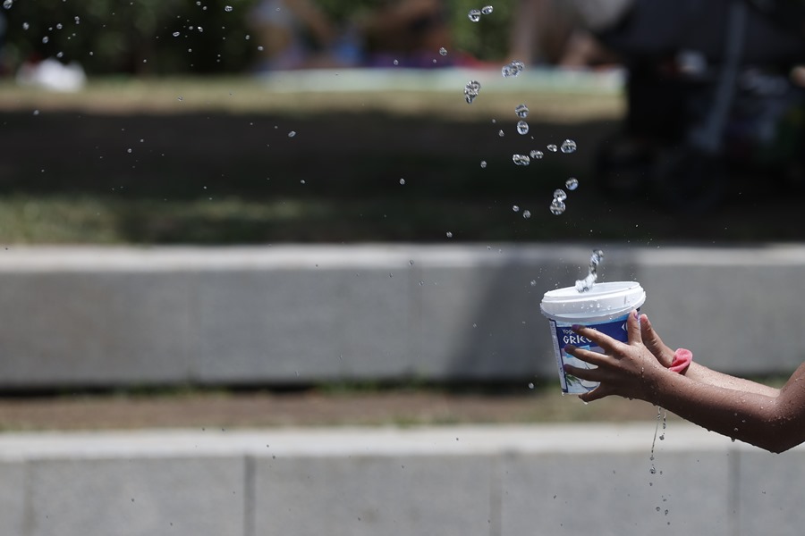 Una niña juega en una fuente de chorros en Madrid